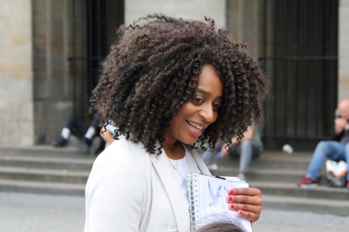 Debora is looking and smiling to a child who stands next to her