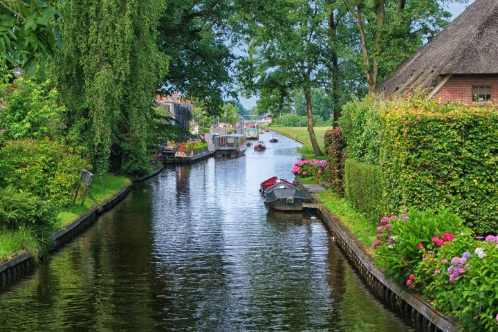 a small boat on a river surrounded by trees