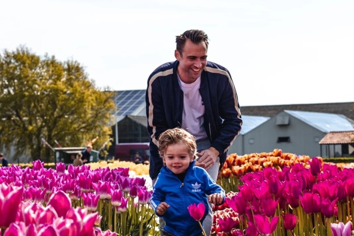 a man holding a purple flower